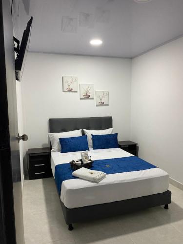 a bedroom with a large bed with blue sheets at Hotel barajas in Plazabonita