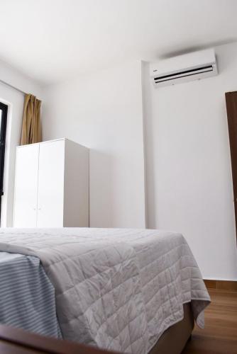 a white bedroom with a bed and a window at Downtown Punta Cana Vibrant Apartment! in Punta Cana