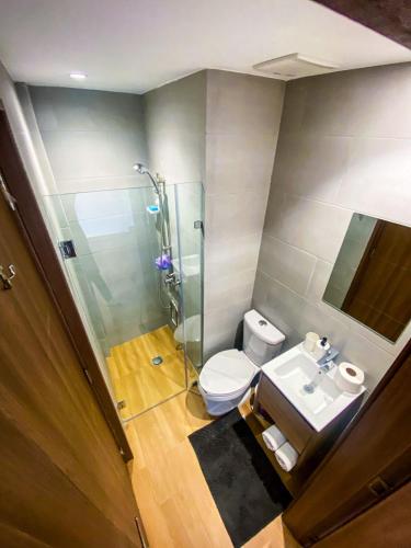 a bathroom with a shower and a toilet and a sink at Downtown Punta Cana Vibrant Apartment! in Punta Cana