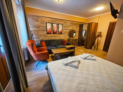 a hotel room with a bed and a couch at Alen Mak Forest Hotel in Lipnik