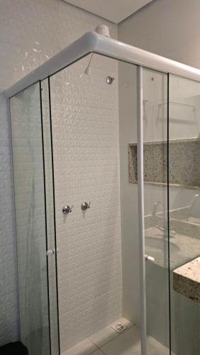 una doccia con una porta in vetro in un bagno di Hotel Habitar Serra do Salitre MG a Serra do Salitre