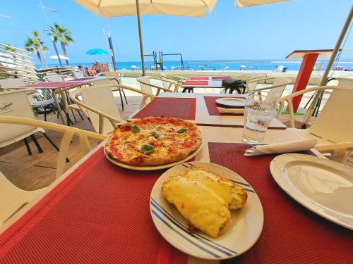 a table with two plates of food and a pizza at Small Oasis #3 in Manilva