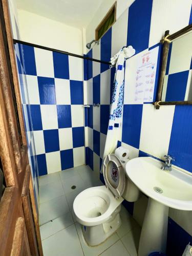 a blue and white bathroom with a toilet and a sink at Hostal Nibuni Palomino in Palomino