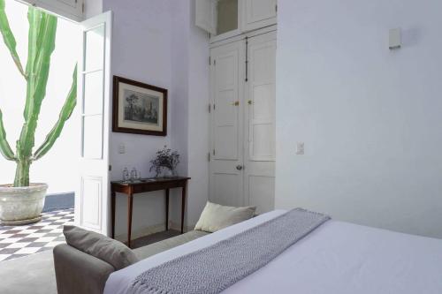 a white bedroom with a bed and a couch at Bohemian Villa in heart of Barranco in Lima