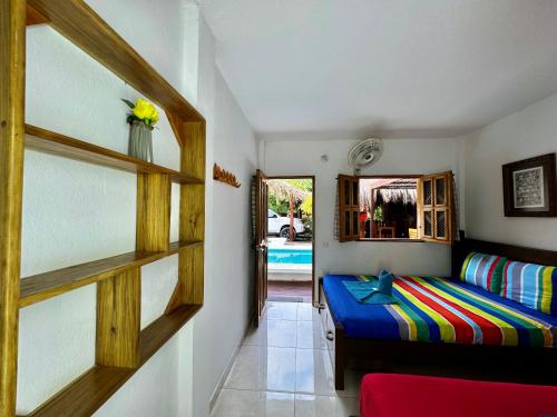 a bedroom with a bed and a room with a pool at Hostal Nibuni Palomino in Palomino