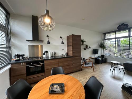 a kitchen with a wooden table and a dining room at De Schelp 86, Garden and Free parking in Zandvoort