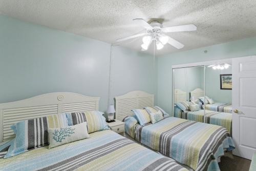 a bedroom with two beds and a ceiling fan at Fifty Gulfside Condominiums in Clearwater Beach