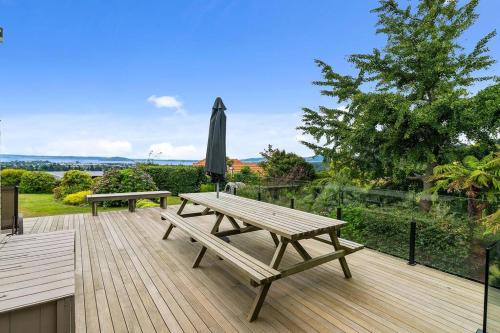 a wooden deck with a picnic table and an umbrella at MTB Paradise in Rotorua