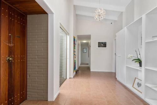a hallway with a brick wall and a chandelier at MTB Paradise in Rotorua