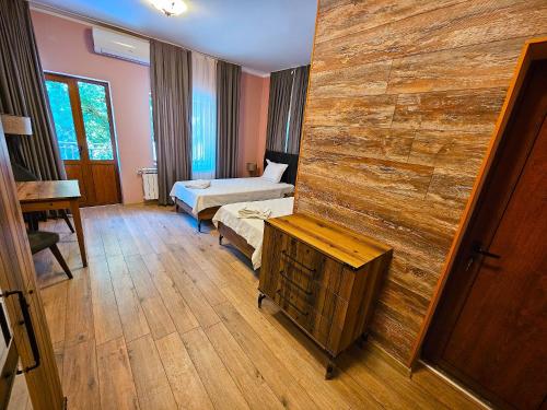 a hotel room with two beds and a wooden wall at Alen Mak Forest Hotel in Lipnik
