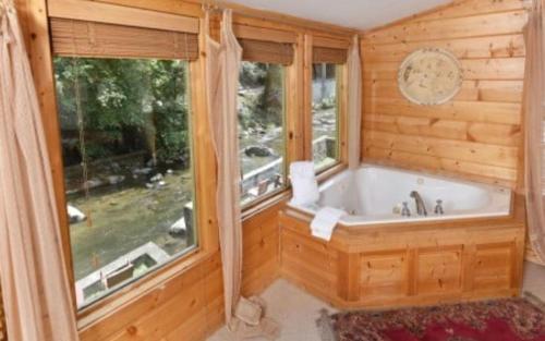 a bathroom with a tub in a log cabin at Simones Cottage in Gatlinburg