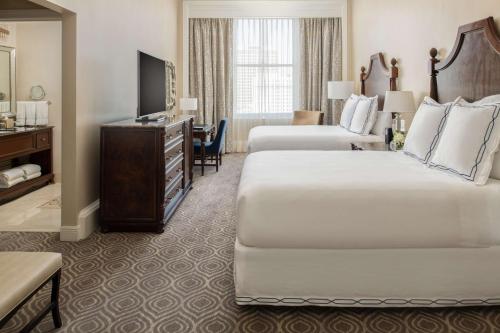 a hotel room with two beds and a television at The Roosevelt Hotel New Orleans - Waldorf Astoria Hotels & Resorts in New Orleans