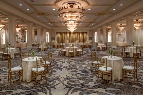 a banquet hall with tables and chairs and a chandelier at The Roosevelt Hotel New Orleans - Waldorf Astoria Hotels & Resorts in New Orleans