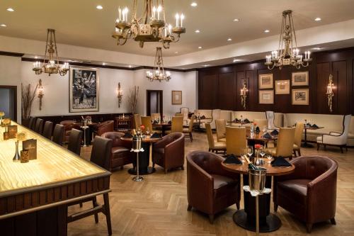 a restaurant with tables and chairs and chandeliers at The Roosevelt Hotel New Orleans - Waldorf Astoria Hotels & Resorts in New Orleans