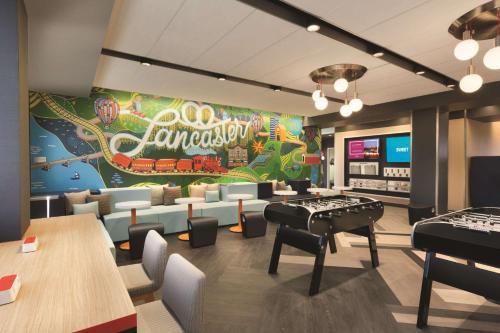 a restaurant with a ping pong table and pianos at Tru By Hilton Lancaster East in Lancaster
