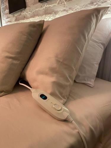 a remote control sitting on a bed with pillows at 103 Para quem procura mobilidade e aconchego em Porto Alegre! in Porto Alegre