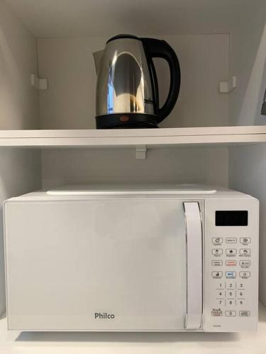 a coffee pot sitting on top of a microwave at 103 Para quem procura mobilidade e aconchego em Porto Alegre! in Porto Alegre
