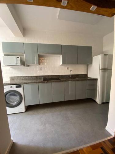 a kitchen with a sink and a washer and dryer at 103 Para quem procura mobilidade e aconchego em Porto Alegre! in Porto Alegre