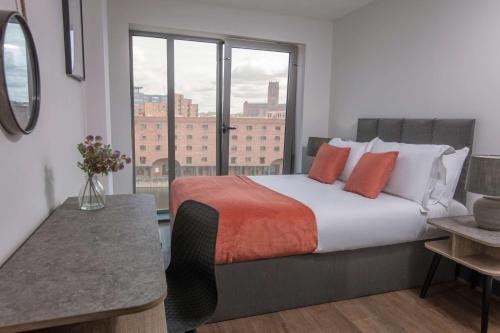 a bedroom with a large bed with a large window at Dockside Aparthotel, Best Western Signature Collection in Liverpool