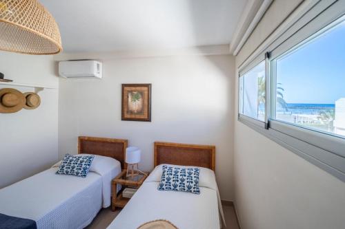 zwei Betten in einem Zimmer mit Meerblick in der Unterkunft Las Nasas, Vistas al Mar, 2 dormitorios in San Agustín