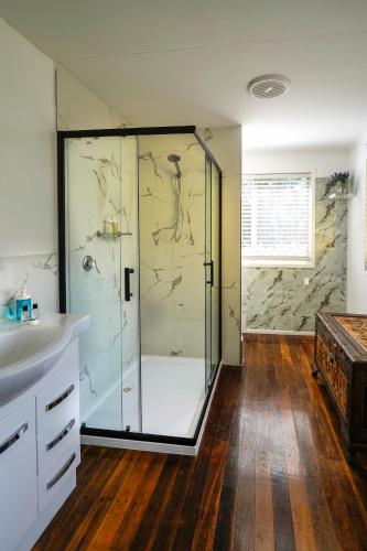 a bathroom with a glass shower and a sink at Yellow Cottage - bush and beach in Agnes Water