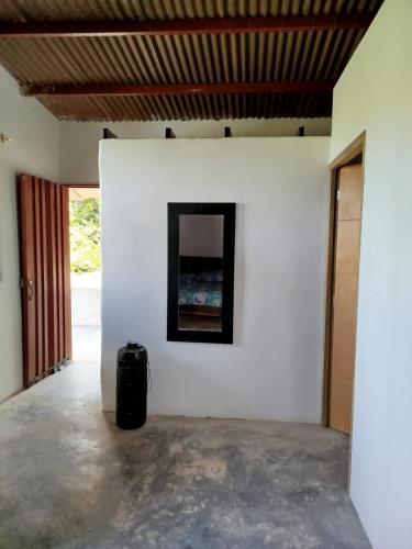 a room with a white wall and a black suitcase at Finca el Eden in San Luis