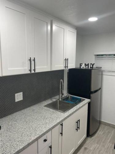 a kitchen with a sink and a refrigerator at Villa New Place in Las Vegas
