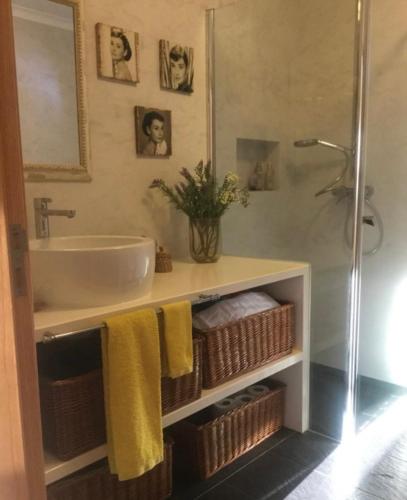 a bathroom with a sink and a shower with towels at Sana Home in Amieira