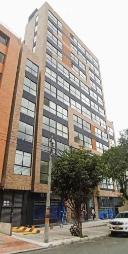 a tall building with a tree in front of it at Roger USAQUEN 120 in Bogotá