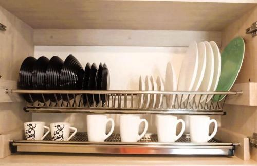 a shelf filled with plates and cups and utensils at Roger USAQUEN 120 in Bogotá