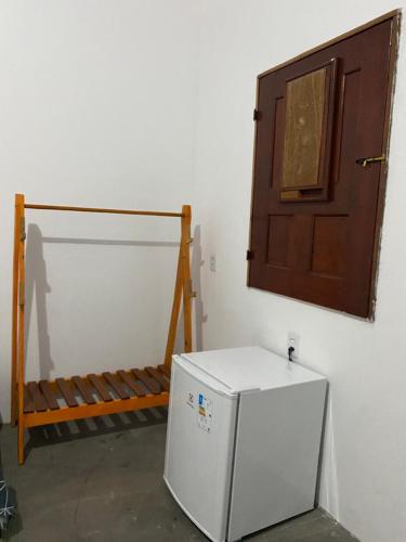 a room with a refrigerator and a wooden door at POUSADA DO BETO in Atins