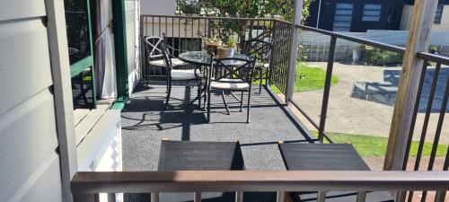 a patio with a table and chairs on a balcony at Blue Marlin Apartments in Whitianga