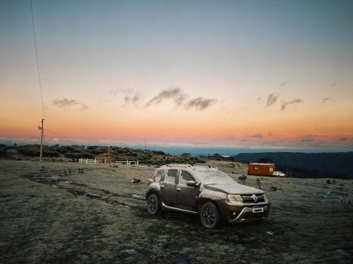 a car parked in a field with the sunset in the background at É diferente, descubra por quê in Urubici
