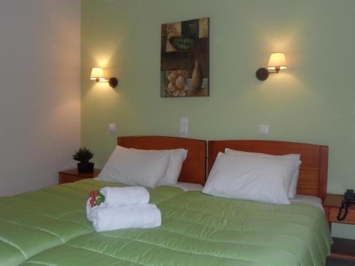 a bedroom with a green bed with towels on it at Filoxenia Marias in Loutra Ipatis