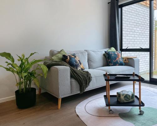 a living room with a couch and a table at Brand New Modern 2BR Townhouse in Auckland