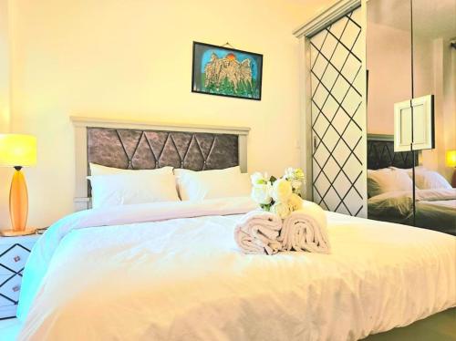a bedroom with a large white bed with flowers on it at cozy cozy in Madinaty