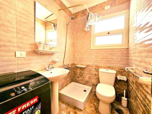 a small bathroom with a toilet and a sink at cozy cozy in Madinaty