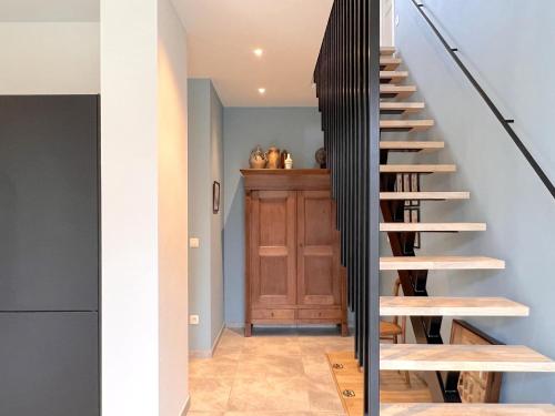a staircase in a house with black railings at Woonhuys in Riemst