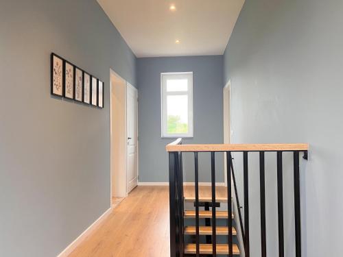 a staircase in a house with blue walls and a window at Achter de Hegge in Riemst