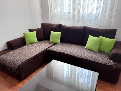 a brown couch with green pillows in a living room at Mario in Ohrid