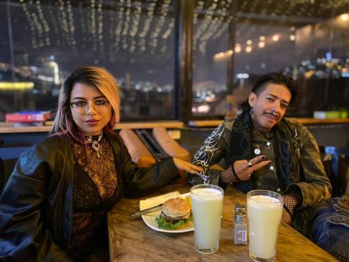 a man and a woman sitting at a table with a plate of food at Hostal La Guayunga RoofTop in Quito