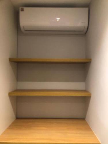 a walk in closet with wooden shelves and a ceiling at Flat Red Sorocaba- Green in Sorocaba