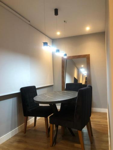 a dining room table with chairs and a mirror at Flat Red Sorocaba- Green in Sorocaba