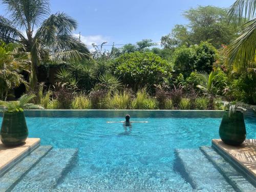 a man in a swimming pool in a resort at Villa YEMAYA - Villa d'hôtes in Ngaparou