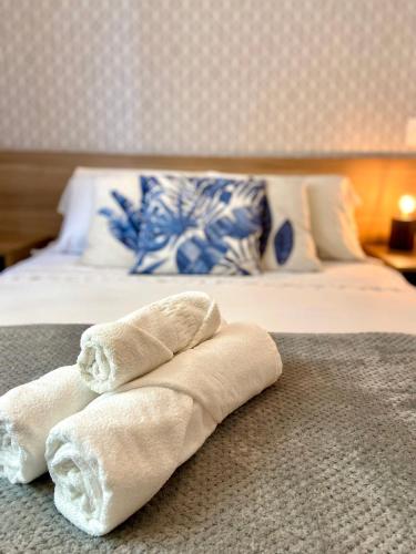 two towels sitting on top of a bed at Atlantis by Mosaico Stays in Vitória