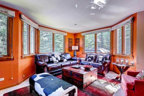 a living room with leather furniture and windows at Kiva 336 by East West Hospitality in Beaver Creek