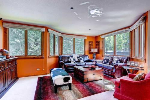 a living room with leather furniture and windows at Kiva 336 by East West Hospitality in Beaver Creek