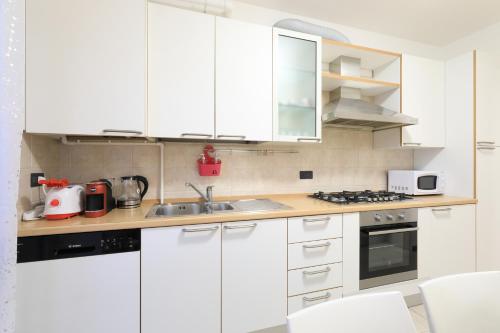 a kitchen with white cabinets and a sink at Central Luxury Apt w Garage Happy Home Bergamo in Bergamo