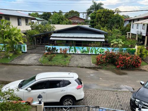 a white car parked in front of a house at Max Garden and Pool in Paramaribo