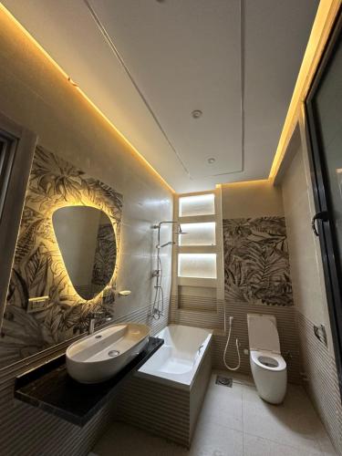 une salle de bain avec un lavabo, des toilettes et un miroir dans l'établissement Twin House in El patio Zahraa, à Sheikh Zayed